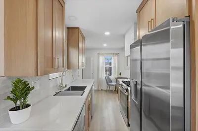 a kitchen with a stainless steel refrigerator and wooden cabinets at One Block to Beach 4BR Game Room and Parking in San Diego