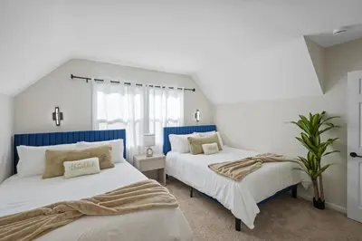 two beds in a room with white walls and blue accents at Sleeps 12 - Hot Tub - Pool - Game Room & Fire Pit! in Hemet