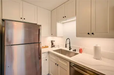 a kitchen with white cabinets and a stainless steel refrigerator at 1BR Close to Downtown SD, Beaches and North Park 1 in San Diego