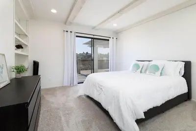 a white bedroom with a bed and a large window at Spacious 4BD, La Jolla, Ocean Views, Jacuzzi in San Diego