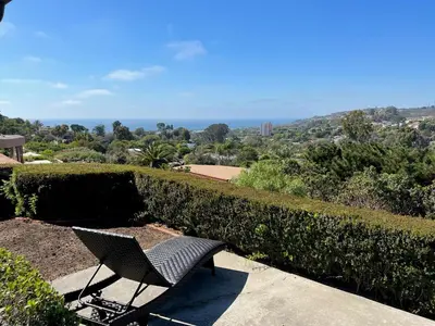 a chair sitting on a sidewalk next to a hedge at Spacious 4BD, La Jolla, Ocean Views, Jacuzzi in San Diego