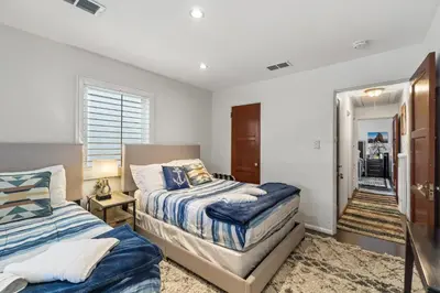a bedroom with two beds and a door to a dining room at Bungalow Downtown Easy Airport Access Family Friendly in San Diego