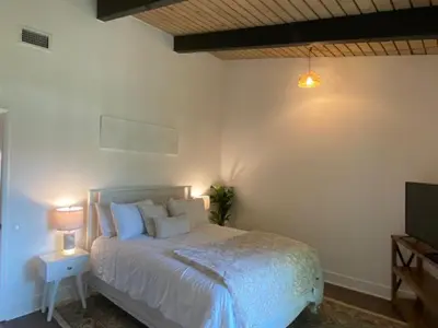 a bedroom with a white bed and a television at Spanish Style San Diego Home Near Beaches in San Diego