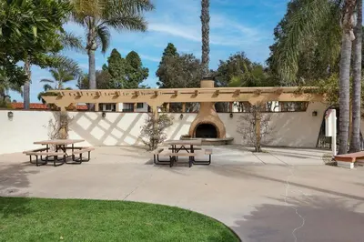a group of picnic tables in a park with palm trees at Spanish Style San Diego Home Near Beaches in San Diego