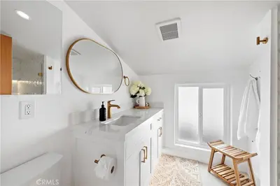 a white bathroom with a sink and a mirror at Beachfront Sunset in San Diego
