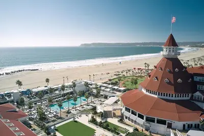 a building on the beach next to a beach at Entire Private Home with 4 Bedrooms - 3 Bathrooms, Big Yard, Garage, King Bed, Crib, Available Now in San Diego