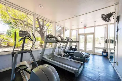 a gym with several tread machines in a room with windows at Luxury Condo Resort Amenities - Pool, Pickleball in San Diego