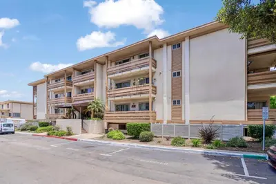 an apartment building with a parking lot at Luxury Condo Resort Amenities - Pool, Pickleball in San Diego