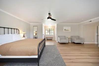a bedroom with a bed and a couch and chairs at Casa Fuerte - Valley Estate w Pool Hot Tub Sports Court in Temecula