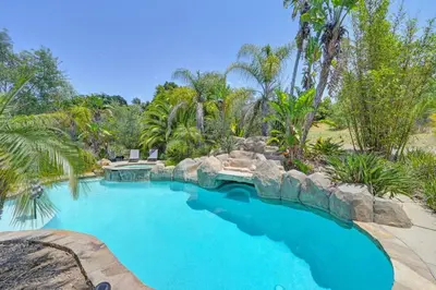 a swimming pool in a resort with a rock wall at Casa Fuerte - Valley Estate w Pool Hot Tub Sports Court in Temecula