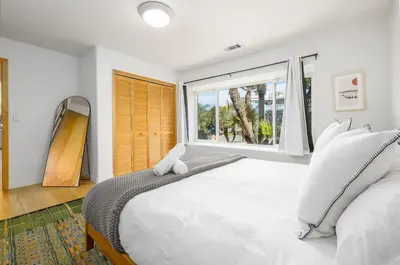 a white bedroom with a large bed and a window at Carlsbad Zen - Large Pool in Carlsbad