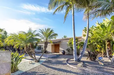 a house with palm trees in front of it at Carlsbad Zen - Large Pool in Carlsbad