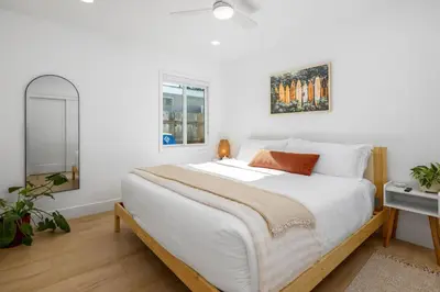 a bedroom with a large bed with white sheets at Carlsbad Bungalow Large Backyard in Carlsbad