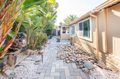 a garden with a stone walkway next to a house at Redwing in San Marcos