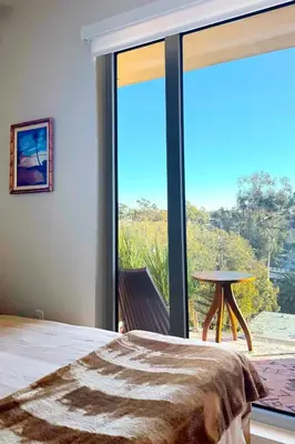 a bedroom with a bed and a large glass window at Luxury Designer Hillcrest Apartment with Pool & Gym in San Diego