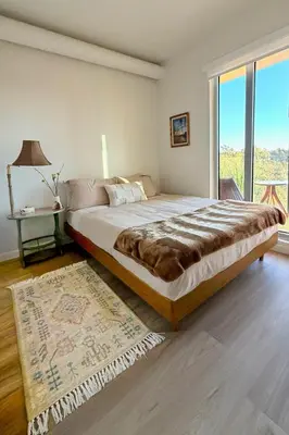 a bedroom with a large bed and a large window at Luxury Designer Hillcrest Apartment with Pool & Gym in San Diego