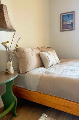 a bed with a table and a vase with flowers on it at Luxury Designer Hillcrest Apartment with Pool & Gym in San Diego