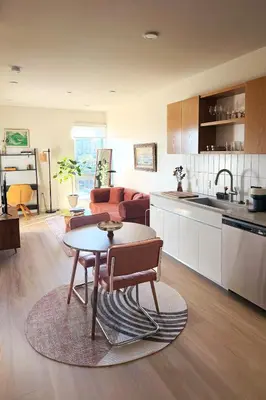 a kitchen and living room with a table in it at Luxury Designer Hillcrest Apartment with Pool & Gym in San Diego