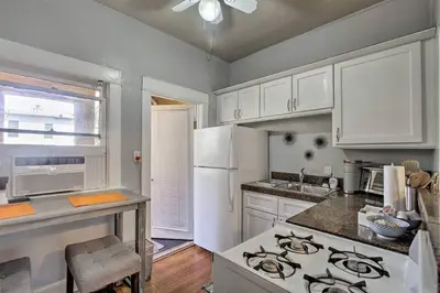 a kitchen with white cabinets and a stove top oven at Entire Building Sleeps 20 I Little Italy in San Diego