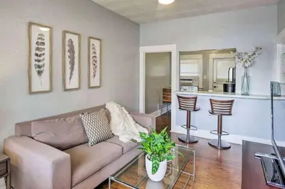 a living room with a couch and a kitchen at Entire Building Sleeps 20 I Little Italy in San Diego