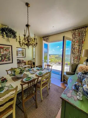 a dining room with a table and chairs and a living room at Beverlys Hilltop Retreat in Fallbrook