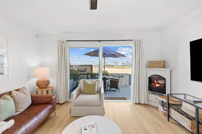 a living room with a couch and a fireplace at Bayfront Getaway | 2BR Retreat w/ Patio & BBQ, Steps to Sand in San Diego