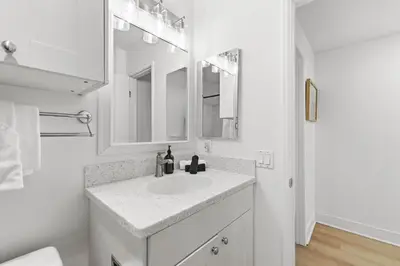 a white bathroom with a sink and a mirror at Bayfront Getaway | 2BR Retreat w/ Patio & BBQ, Steps to Sand in San Diego