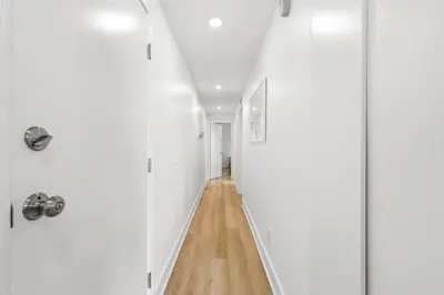 a hallway with white walls and a wooden floor at Cozy 2BR Bayfront Home | Patio + Water Views in Mission Beach in San Diego