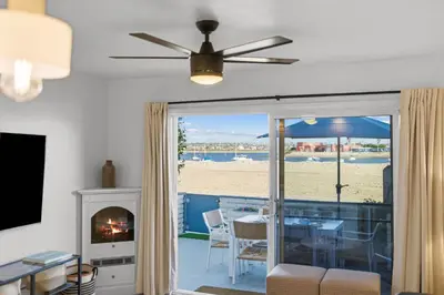 a living room with a fireplace and a view of the beach at Cozy 2BR Bayfront Home | Patio + Water Views in Mission Beach in San Diego