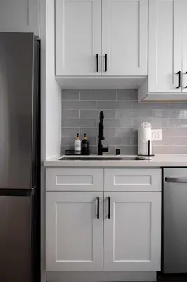 a kitchen with white cabinets and a stainless steel refrigerator at Walk to Balboa and Zoo Central Renovated Villa in San Diego