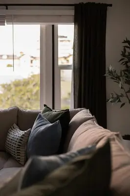 a couch with pillows sitting in front of a window at Walk to Balboa and Zoo Central Renovated Villa in San Diego