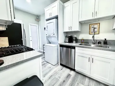 a kitchen with white cabinets and stainless steel appliances at A Walkable Music-Themed Escape Near Downtown in San Diego