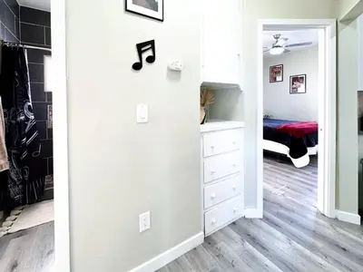 a bedroom with white walls and a closet with a dresser at A Walkable Music-Themed Escape Near Downtown in San Diego