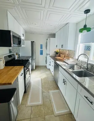 a kitchen with white cabinets and stainless steel appliances at The North Park Stay in San Diego in San Diego
