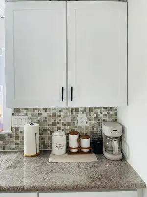 a kitchen counter with white cabinets and coffee makers at The North Park Stay in San Diego in San Diego