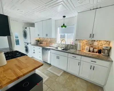a large white kitchen with white cabinets and appliances at The North Park Stay in San Diego in San Diego