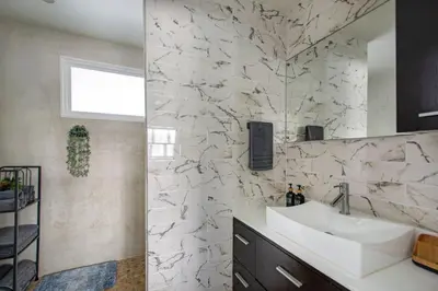 a bathroom with a sink and a white marble wall at Marina Del Mar 203A in Oceanside