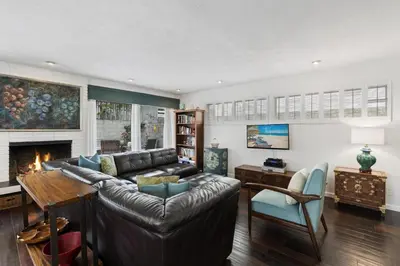 a living room with a leather couch and a fireplace at 5Br Retreat With Balcony And Patio, 2 Homes From Sand By Beachview Rentals in Newport Beach