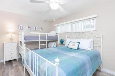 a bedroom with a bed and two bunk beds at Coastal 4Br Retreat, Just Steps From 44Th St Beach in Newport Beach