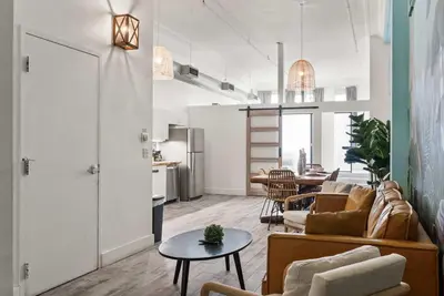 a living room with a couch and a table at Downtown Gaslamp Getaway Stylish 4BR APT in San Diego