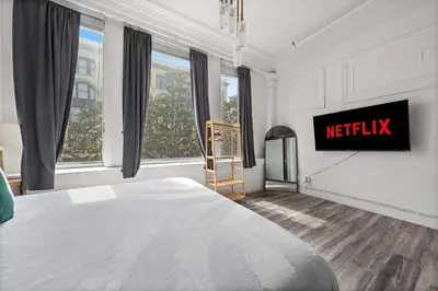 a bedroom with a bed and a tv on a wall at Downtown Gaslamp Getaway Stylish 4BR APT in San Diego