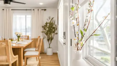 a dining room with a table and a vase with flowers at Hot Tub • BBQ Island • Outdoor Living • Near San Diego Beaches Glidden Glow by AvantStay in San Diego