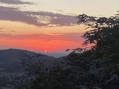 a sunset on a mountain with the sun in the sky at Quiet Hilltop Home With Stunning Hill Top And Valley Views in Valley Center