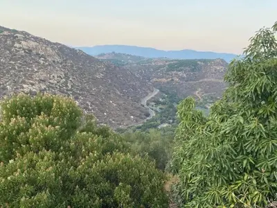 a view of a valley with trees and a river at Quiet Hilltop Home With Stunning Hill Top And Valley Views in Valley Center