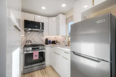 a kitchen with a stainless steel refrigerator and white cabinets at Monarch Cove - Unit B For 2ppl in Oceanside