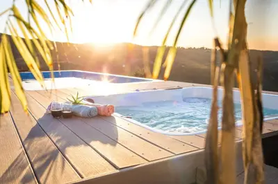 a hot tub sitting on a deck next to a palm tree at Vista Oasis with Spa, Pool, & Views in Vista