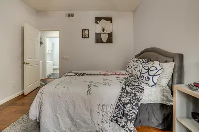 a bedroom with a bed with a gray and white comforter at Sip, Hike and Explore Quiet SoCal Studio with Patio! in Winchester
