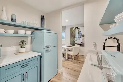 a kitchen with a blue refrigerator and a table at ON Avenida Del Mar Heart of Downtown 10 minute WALK to the Pier Parking in San Clemente