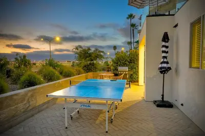a ping pong table on the balcony of a house at Luxury Carlsbad Retreat | Across The Street From Beach | Firepit, BBQ, Ping Pong, Cornhole & More in Carlsbad