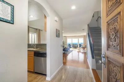 a kitchen with a door leading to a living room at Luxury Coastal Escape | Sleeps 4 | Ocean Views + Resort Amenities in Carlsbad